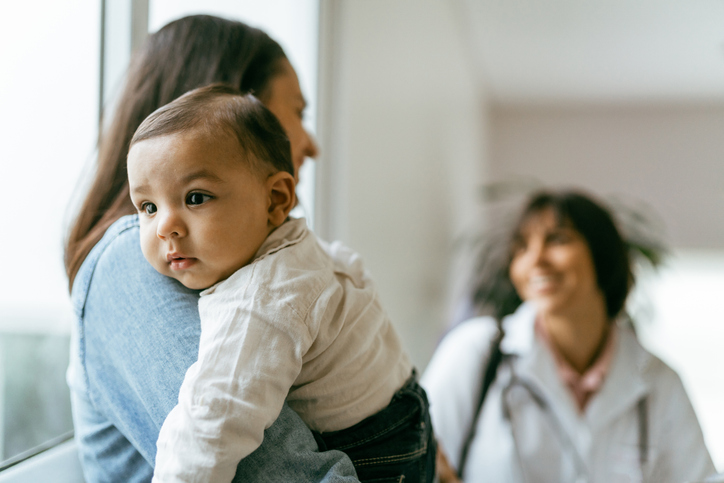 woman holding baby talking to doctor